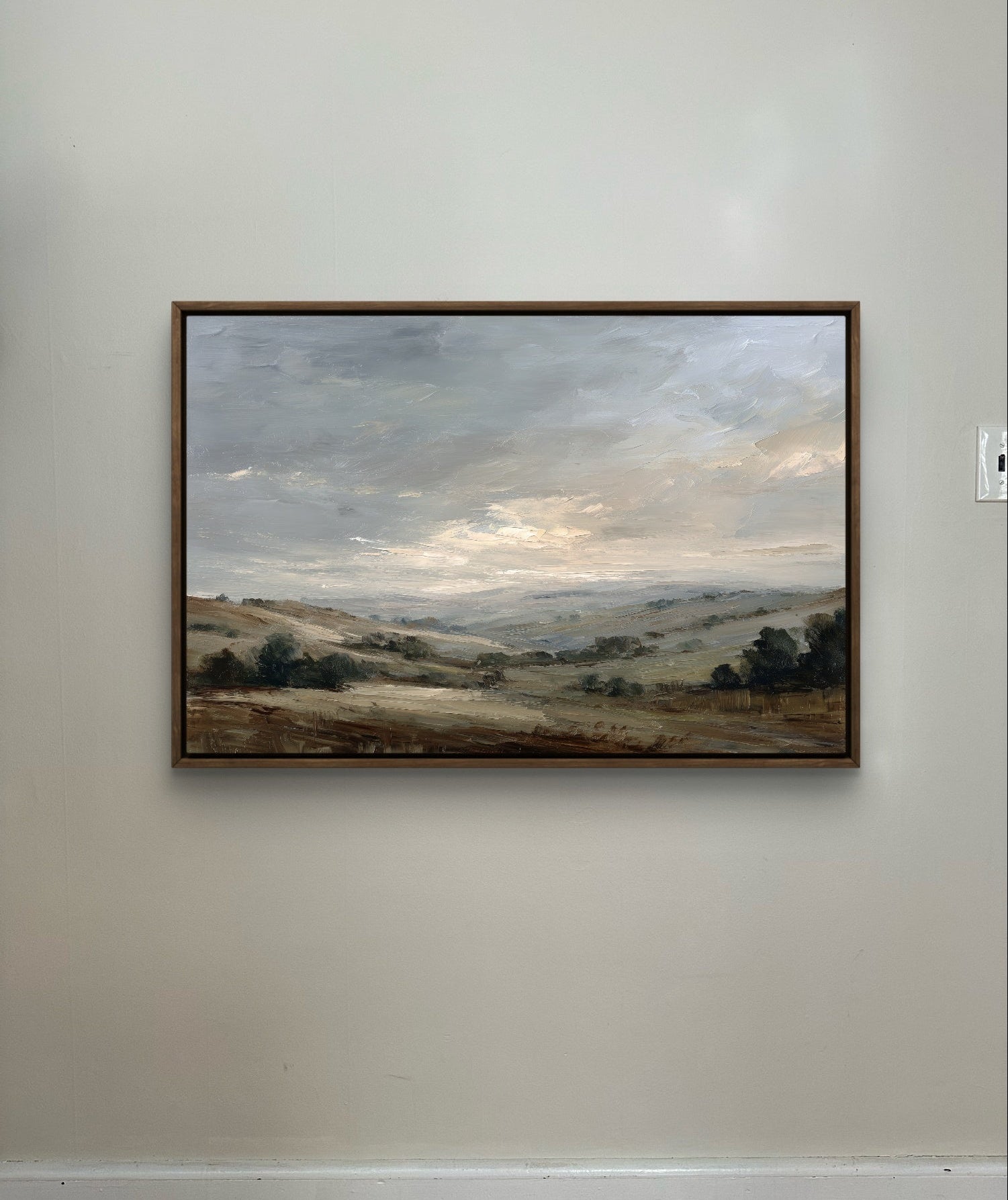 Framed landscape painting on a plain wall