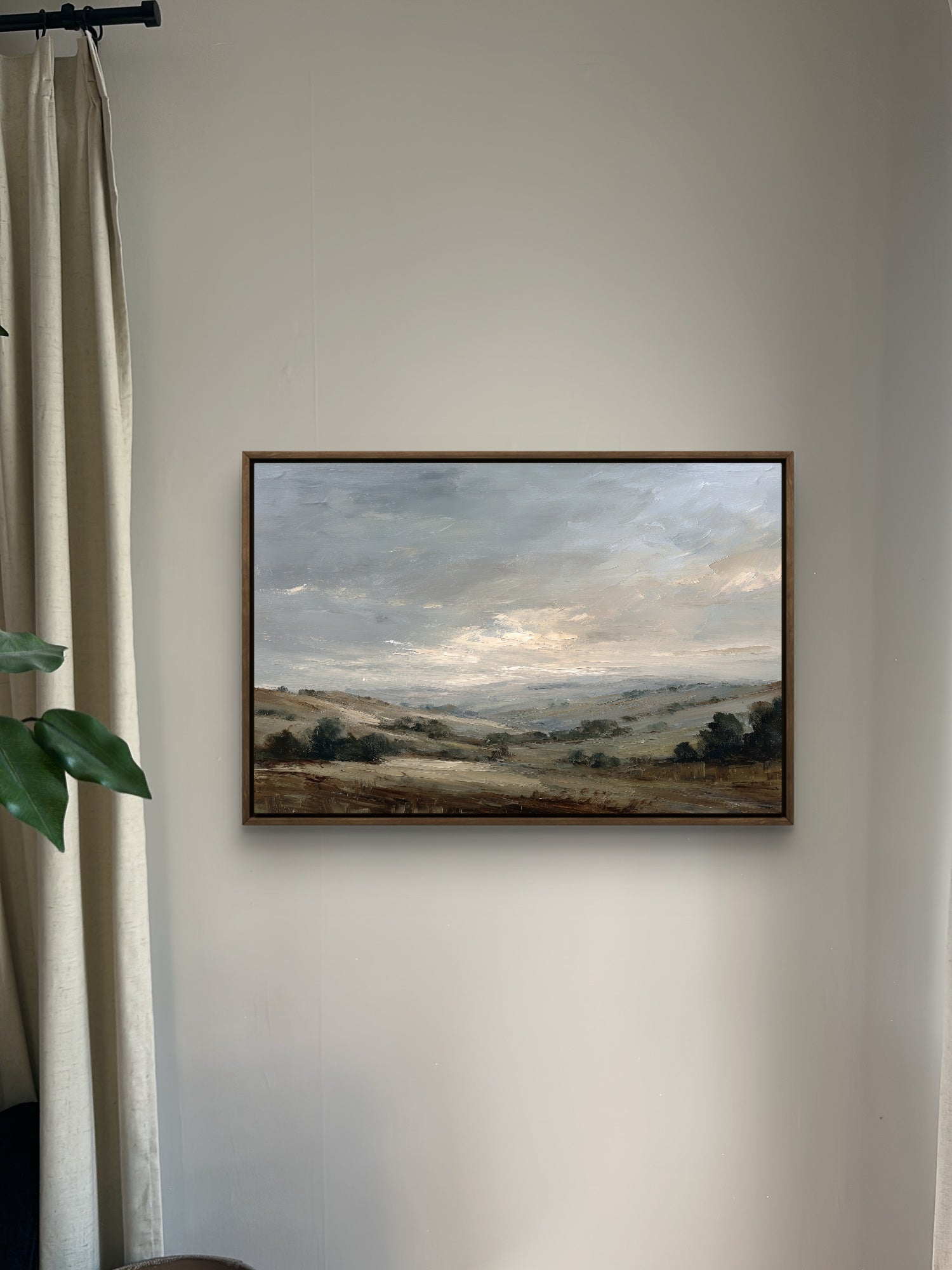 Framed landscape painting on a wall with a neutral background